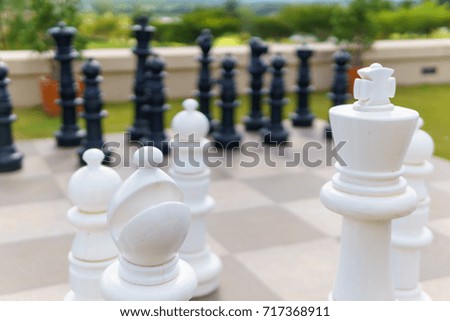 close up of big white wood chess on the chessboard floor with black wood chess background. decision concept.