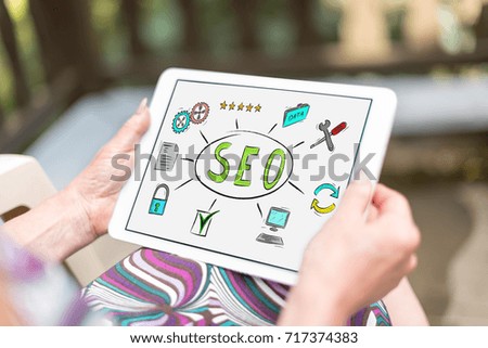Seo concept shown on a tablet held by a woman