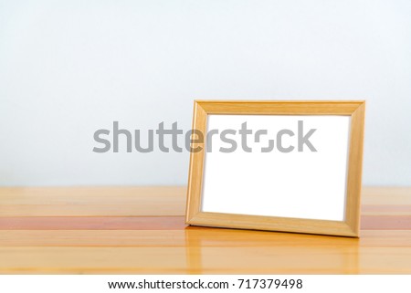 Empty wood photo frame on bright wooden table with copy space, picture memory.