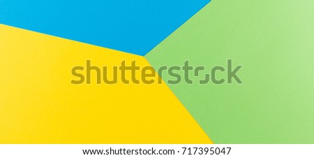 Color papers geometry flat composition banner background with blue, green and yellow tones.