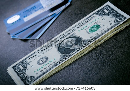 One dollar banknotes on a black table with credit cards. Cash money american dollars. Vintage background. Lens flare. American currency. Internet banking