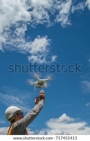 Young engineer use drones outdoor with beautiful sky with clouds, the man holding Drone