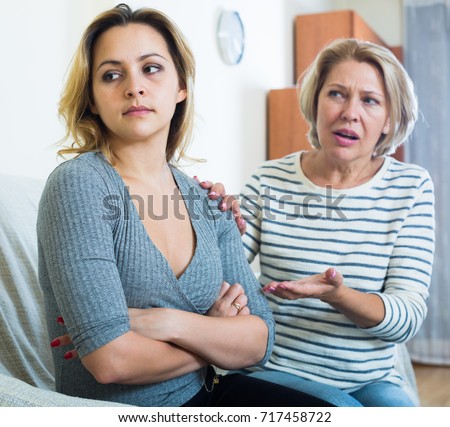 Furious mature woman screaming on daughter in law indoors Royalty-Free Stock Photo #717458722