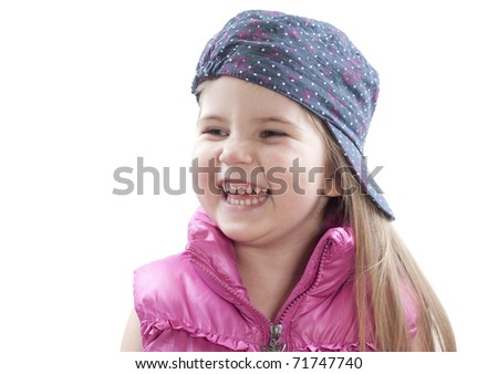 little girl wearing baseball cap and hlaughing on white
