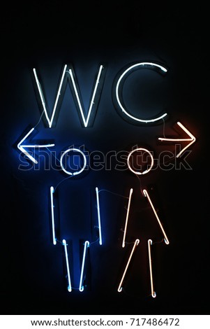 Neon sign of toilet on wall