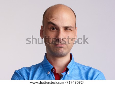 Man face with raised eyebrow isolated on grey. Doubting guy