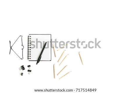 Working space with telephone, notebooks, pencils, flower and glasses on a white background. Top view, ftat lay