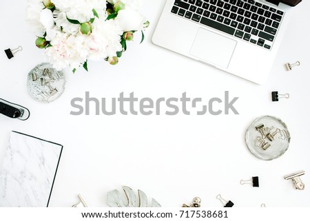 Flat lay home office desk frame with space for text. Female workspace with laptop, white peony flowers bouquet, accessories, marble diary on white background. Top view feminine background.