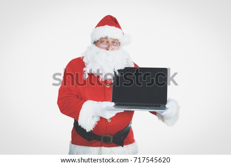 Santa Claus presents a laptop on white background.