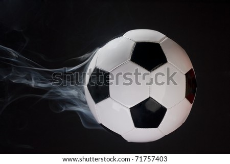 Smoking soccer ball illusion shot against a black background.