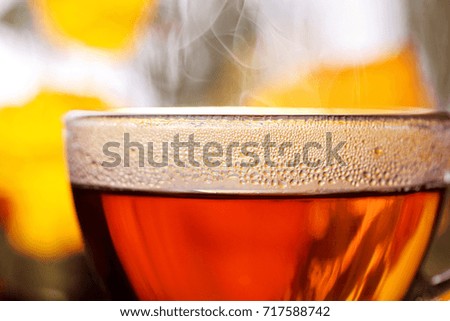 Closeup cup of hot tea.Defocused rainy window and autumn trees on second plan.Selective focus.Autumn concept .Hot beverages