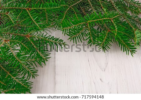 Christmas decoration, frame concept background, top view with copy space on white wood table surface. Christmas ornaments border with fir tree branches