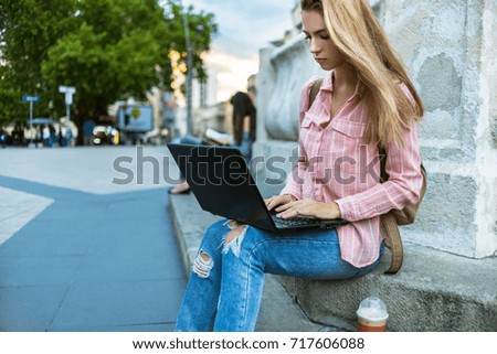 Girl working on the laptop in the city