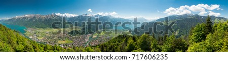 A beautiful view of Interlaken town, Eiger, Mönch and Jungfrau mountains and of Lake Thun and Lake Brienz from Two Lakes Bridge viewing platform on Harder Kulm, Switzerland. Royalty-Free Stock Photo #717606235
