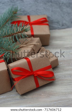 Christmas gift box with red ribbon on wooden background with Fir branches, snowflakes. Xmas and Happy New Year composition. Flat lay, vertical