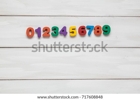 Color numeral on white wooden background