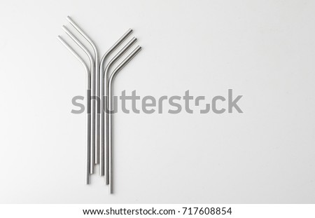 High angle view of six metal drinking straws arranged on white background Royalty-Free Stock Photo #717608854