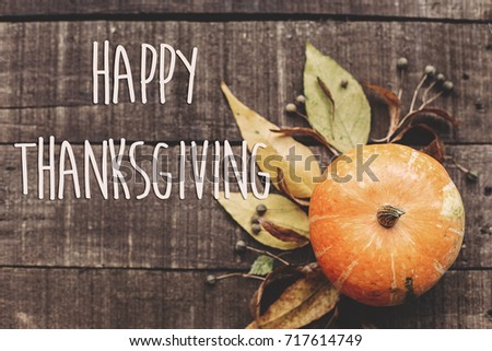 happy thanksgiving text sign, greeting card. fall image flat lay. beautiful pumpkin and leaves and berries on rustic wooden background, top view. cozy autumn mood. fall holiday