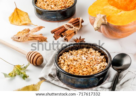Dietary autumn pastries, breakfast. Crumble pumpkin pie, maple syrup and oatmeal flakes, in plate saucers, on a white marble table. Copy space