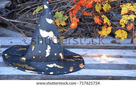 Halloween holiday concept. Pumpkins, witch hat, on wooden old table candles