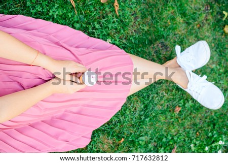 concept photo woman hold ice cream while sitting on the grass