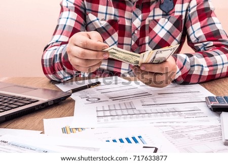 man counts money for office work and computer calculation of the budget