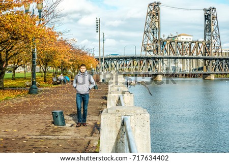 Man walking along the riverwalk in Portland city at autumn, Oregon, USA.