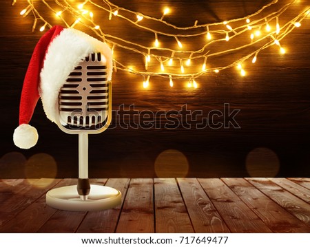 Microphone with Santa hat and garland on background. Christmas music concept