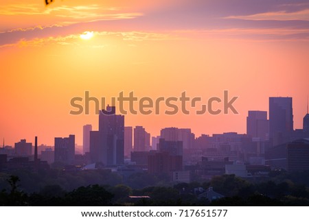 sunset with the minneapolis minnesota skyline. the sky is yellow, gold and pink