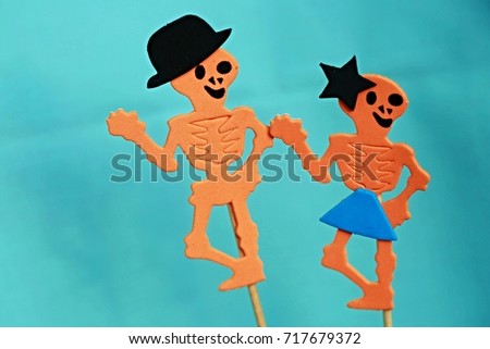 Two funny orange Halloween skeletons with blue background - man and woman in love 