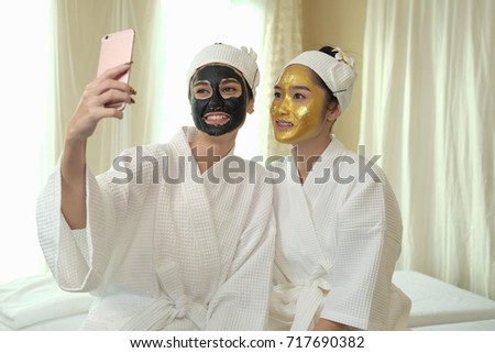Two women are using a smartphone for selfie while in the spa.