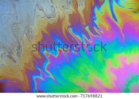 Gasoline stains on the water surface. Bright, colored texture, background. Ecological problem. Water pollution. Royalty-Free Stock Photo #717698821