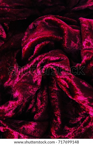 Red velvet  dress material cloth texture pattern. 
tailoring stitching concept. Shiny beautiful fashion fabric. Shiny clothing material sample.Creased fabric.