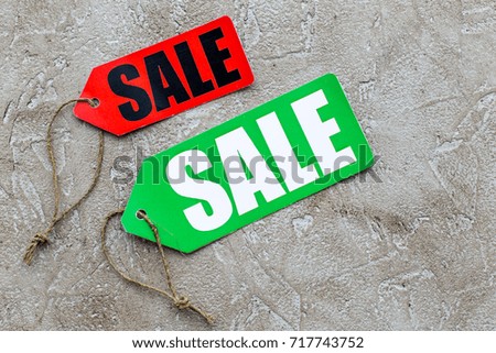 Colored sale labels on light stone background top view copyspace