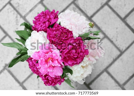 Beautiful bouquet of peonies on paving slabs, outdoors