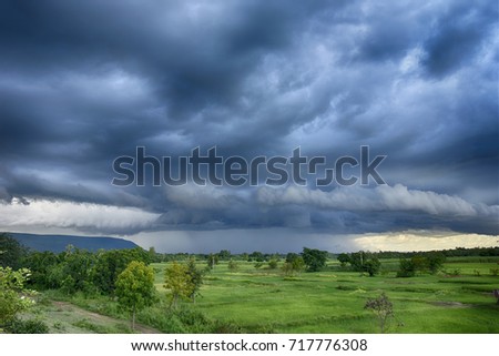 Rain cloud over mountain and agriculture area. Royalty-Free Stock Photo #717776308
