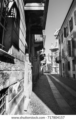 Architecture of the Medieval Piedmont City of Cuneo in Italy. Vintage Italian lamps and balconies in Mediterranean style. Black and white picture