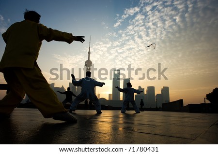 SHANGHAI - November 21:  People playing Taiji on the Bund , Oriental Pearl Tower in the distance, on November 21, 2010 in Shanghai, China.  One of the Top Ten Shanghai Attractions.