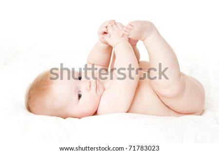 happy baby playing with his feet, on white background