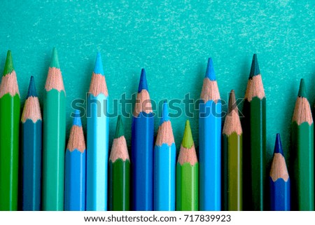 Blue colored pencils in a zigzag on a blue background.                               
