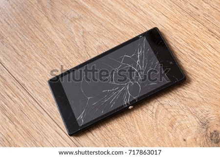 Broken smartphone, on wooden background