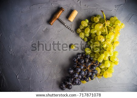 Organic ripe grape and vintage corkscrew on rustic background as a wine concept