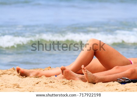 Woman and may lay on a sandy beach by the sea or ocean. Summer vacations concept