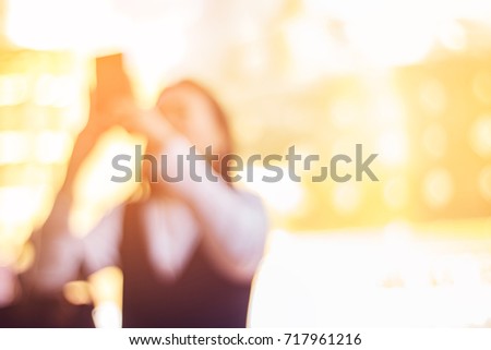 abstract blur and defocused traveller using smartphone to take photo in golden temple with sunlight effect for background