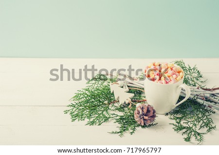 Winter Composition of Cup Cacao with Marshmallow decorated Fir tree Branches and pine cone on White Wooden Background Selective Focus Vintage color Toning. New year or Christmas card with Copy space