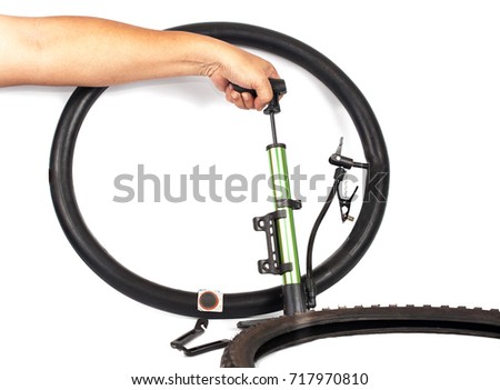 hand pumping air into bike tire 
