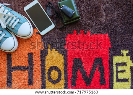 Welcome home carpet with shoes,smartphone,wallet and key of car on it,welcome concept.