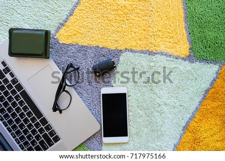 Welcome home carpet with laptop,glasses,wallet,smartphone and key of car on it,welcome concept.