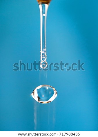 Lemon-shaped water drop on blue blurred background.