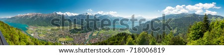 A beautiful view of Interlaken town, Eiger, Mönch and Jungfrau mountains and of Lake Thun and Lake Brienz from Two Lakes Bridge viewing platform on Harder Kulm, Switzerland. Royalty-Free Stock Photo #718006819
